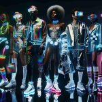 A vivid, high-definition image showing the trend of cyber fashion rising. Imagine individuals demonstrating their unique style through eccentric clothing, illuminated by neon lights. All the persons involved have their own distinct style that embraces the cyber aesthetic, including LED adornments, futuristic patterns, and glossy metallic textiles. Picture a diverse array of models, an African female model rocking light-up sneakers, an Asian male model flaunting a silver holographic jacket, a Caucasian female model carrying an LED-infused handbag, and a Middle-Eastern male model sporting VR goggles.